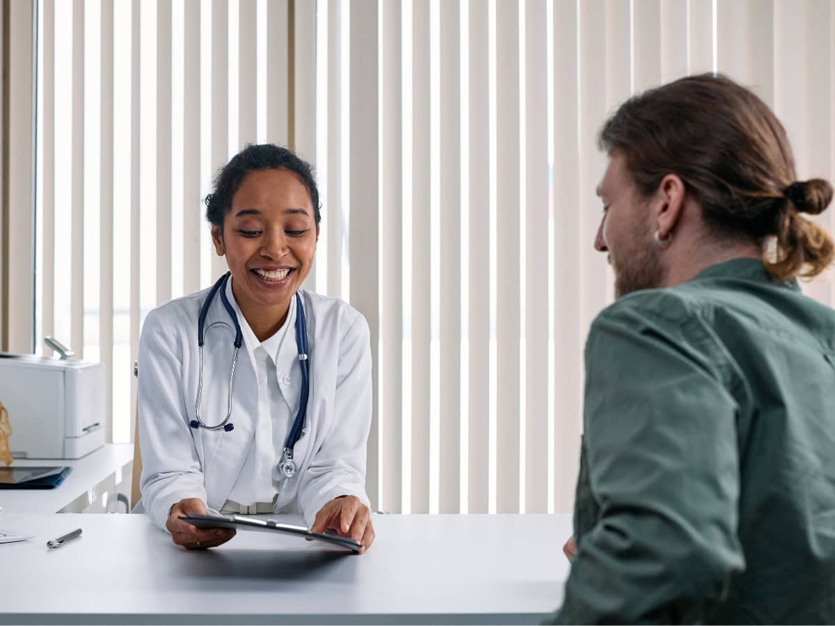 Médica genera confianza comunicando con su paciente de manera empática y clara